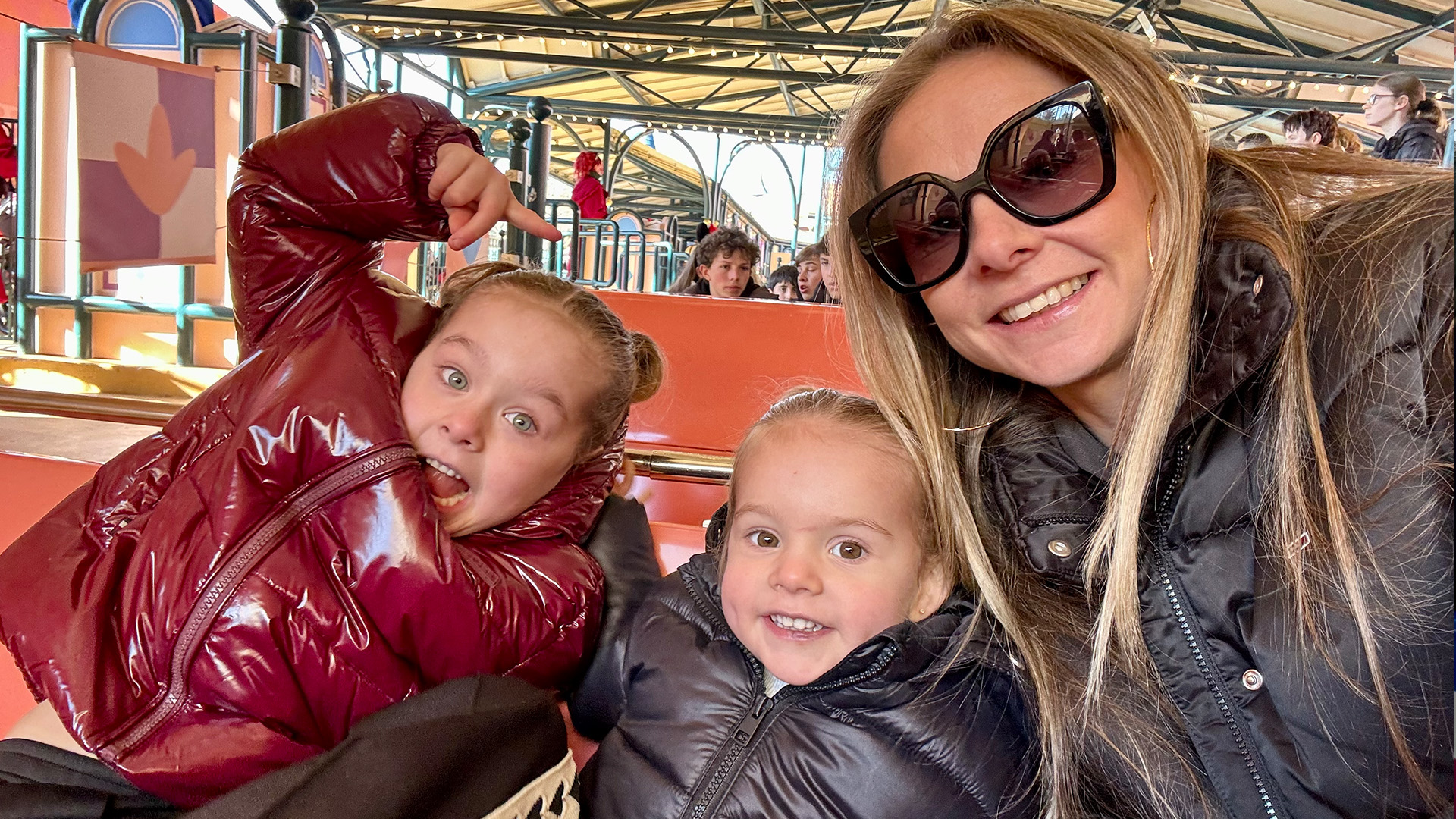 Tatjana maakt een vrolijke selfie met haar dochters Lola en Gina tijdens de rit in de attractie 'it's a small world'.