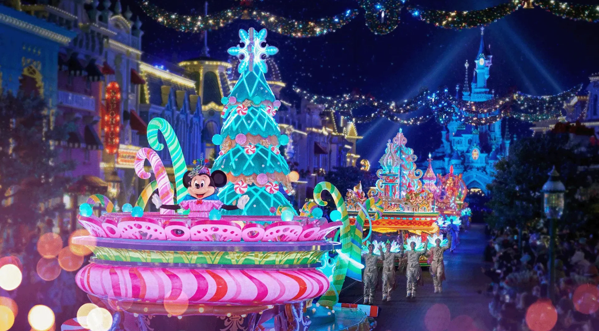 Minnie op een roze met blauwe paradewagen met kerstboom leidt de kerstparade stoet